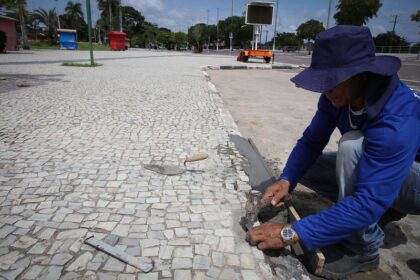 Reposição manual de pedras portuguesas no parque Ponta Negra